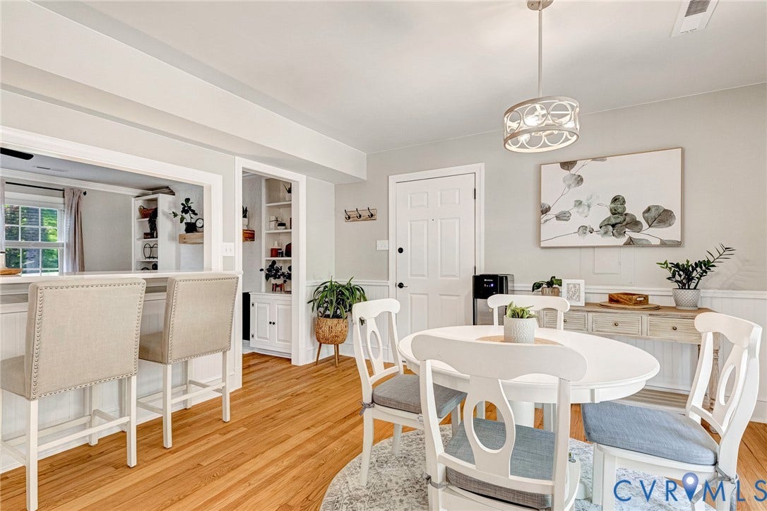8800 Shewsbury Drive, New Kent, VA 23124 Hardwood flooring throughout the dining area, featuring wainscoting and a decorative ceiling light fixture
