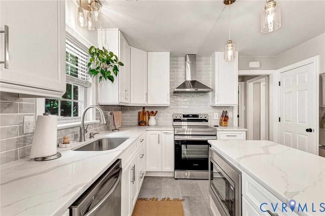 8800 Shewsbury Drive, New Kent, VA 23124 White shaker cabinetry, light-toned countertops, subway tile backsplash, stainless steel appliances, and a central island with integrated microwave
