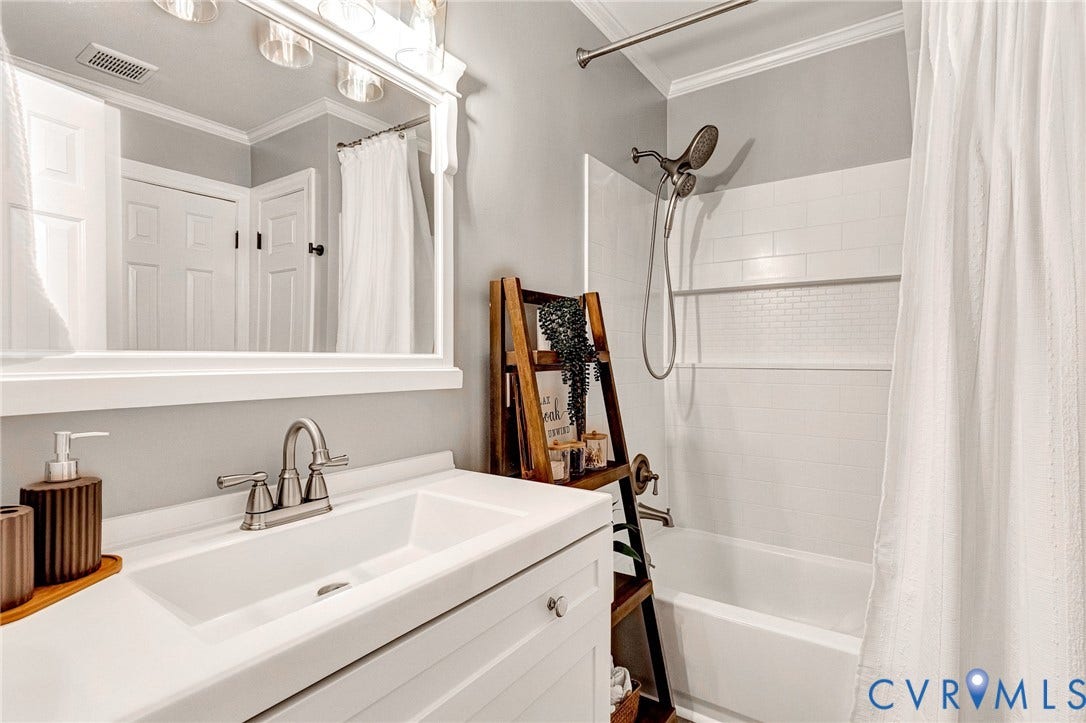 8800 Shewsbury Drive, New Kent, VA 23124 Bathroom featuring a white vanity with an integrated sink, brushed nickel faucet, and a large framed mirror