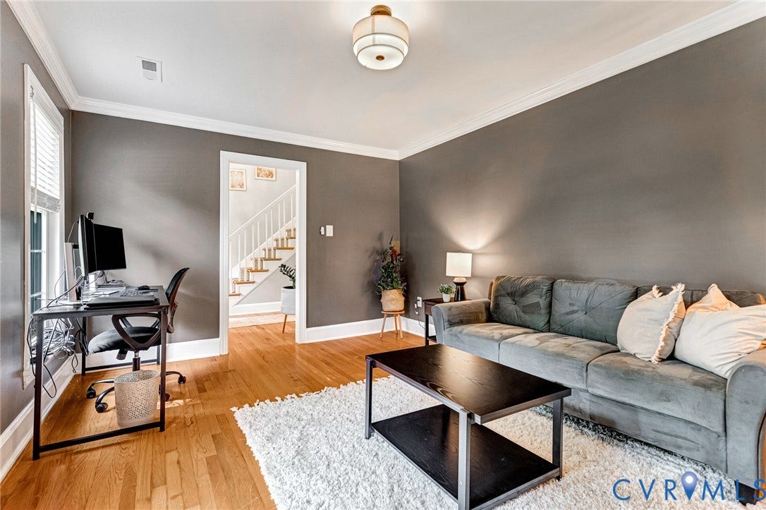 8800 Shewsbury Drive, New Kent, VA 23124 Living area with hardwood flooring, crown molding, a ceiling-mounted light fixture, and a doorway revealing a staircase