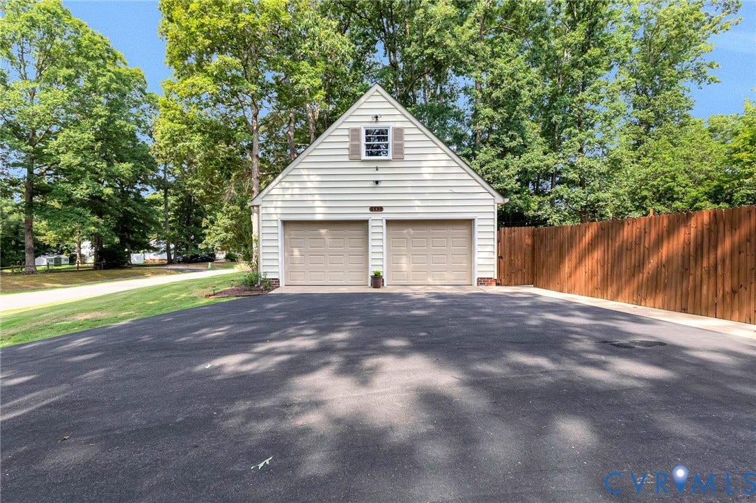 8800 Shewsbury Drive, New Kent, VA 23124 Detached two-car garage with white siding, shuttered gable window, and asphalt driveway