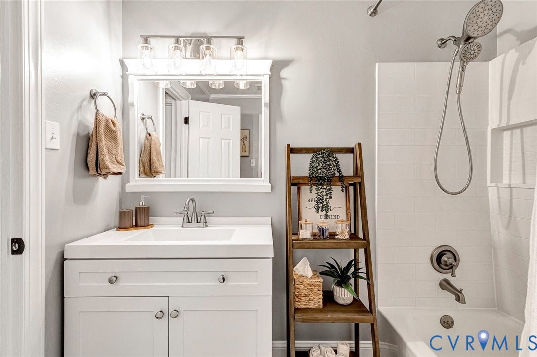 8800 Shewsbury Drive, New Kent, VA 23124 Bathroom featuring a vanity with an integrated sink, brushed nickel faucet, and a wall-mounted mirror with a four-light fixture