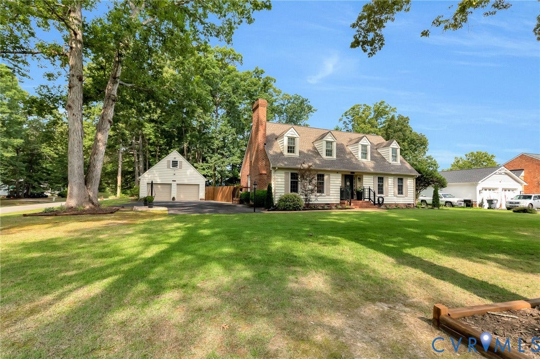 8800 Shewsbury Drive, New Kent, VA 23124 Colonial-style residence featuring a brick chimney, dormer windows, and a detached two-car garage with a gable roof