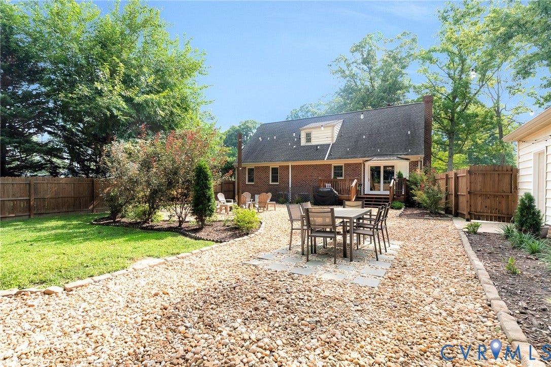 8800 Shewsbury Drive, New Kent, VA 23124 Expansive backyard featuring a gravel patio with pavers, a terraced deck, and a manicured lawn
