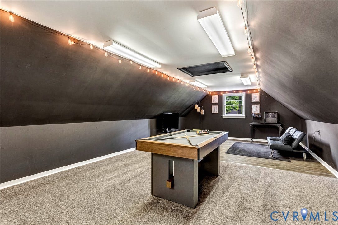 8800 Shewsbury Drive, New Kent, VA 23124 Versatile bonus room featuring vaulted ceilings, a skylight, window, and a combination of carpeting and wood-finish flooring