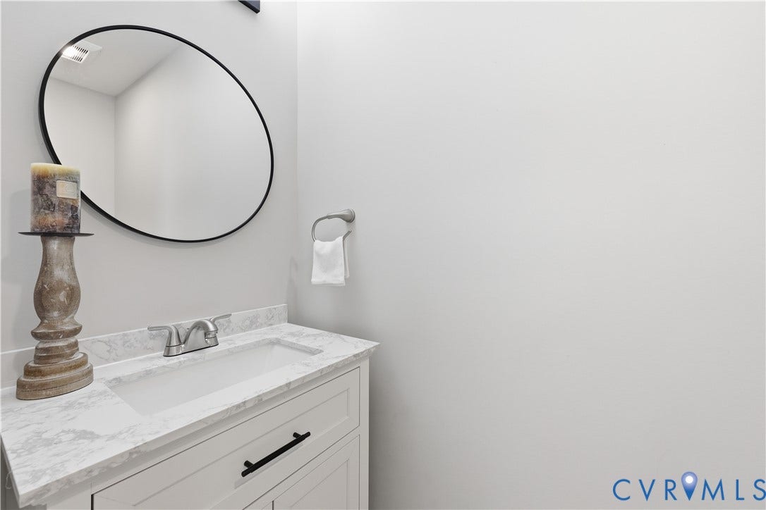 Half Bath White vanity with an integrated rectangular sink, light-toned countertop, and brushed nickel faucet