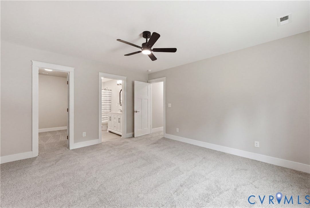 Spacious room featuring light gray carpeting and neutral wall tones