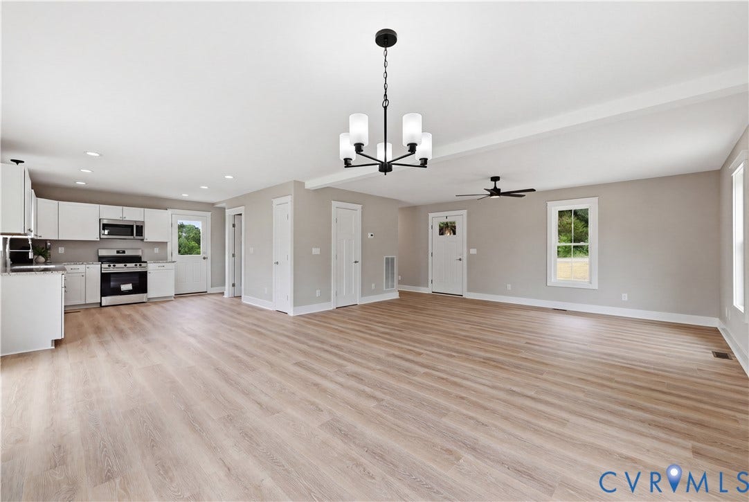 Expansive open-concept living space featuring wood-finish flooring and recessed lighting