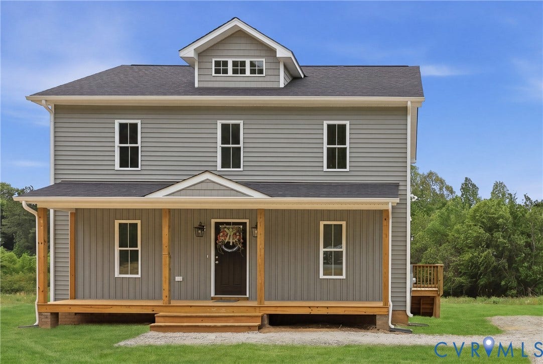 Two-story residence featuring gray siding, a covered front porch with natural wood posts, and a black shingle roof