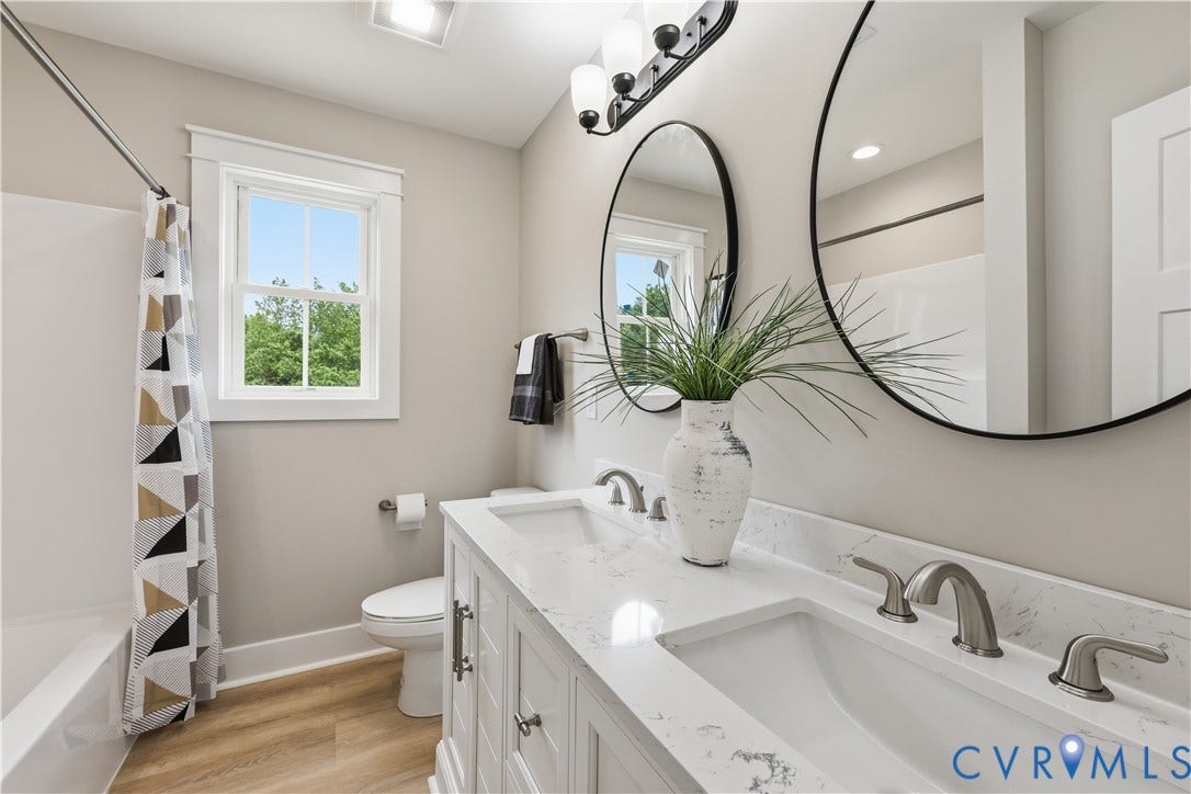 Hall bath Double vanity featuring integrated sinks, light-toned countertops, and brushed nickel fixtures