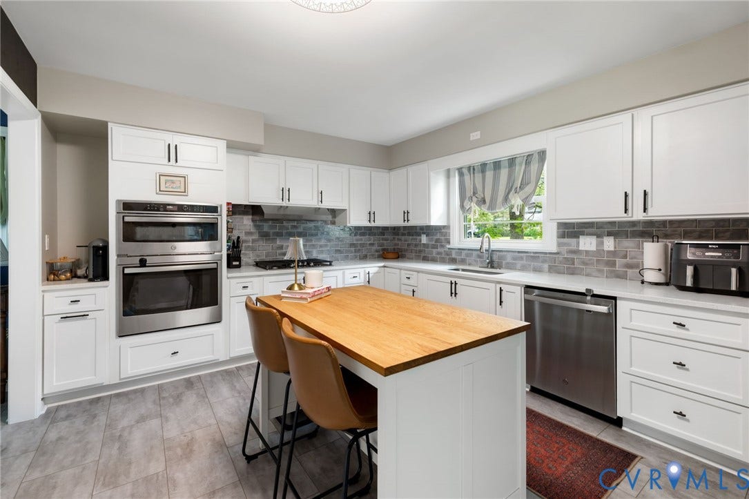 404 Aubery Road, Henrico, VA 23229 Bright kitchen featuring white shaker cabinetry, a wood-finish island countertop, grey subway tile backsplash, and light-toned flooring