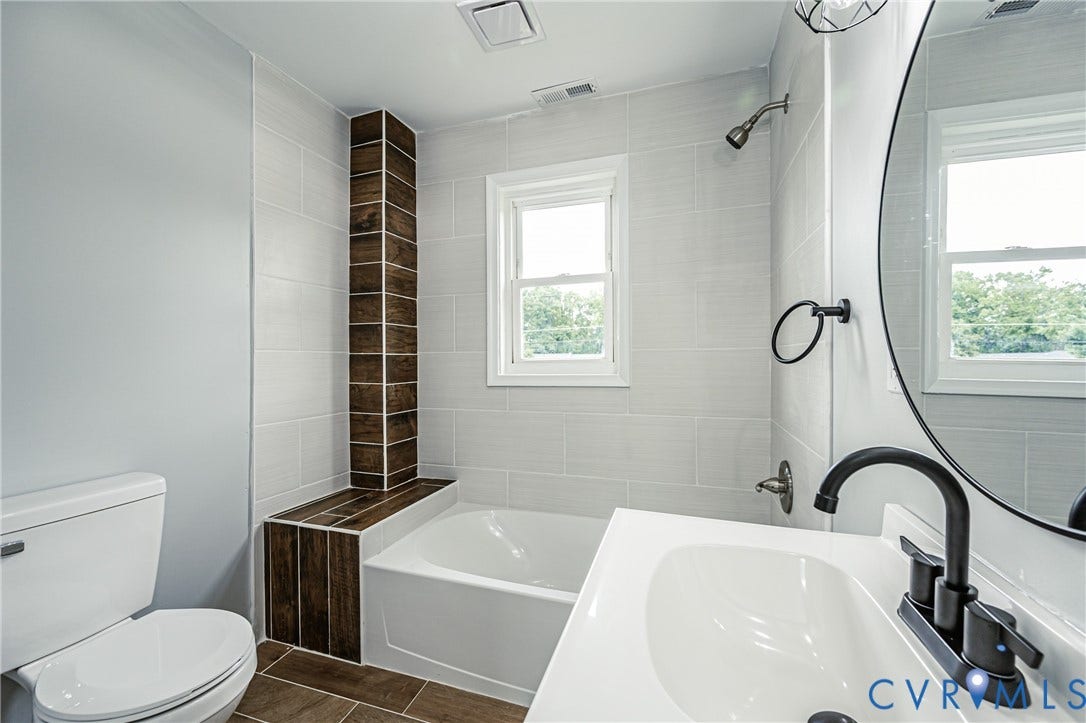 3903 Delmont Street, Henrico, VA 23222 Bathroom featuring a white bathtub, white vanity with integrated sink, matte black faucet, and a round mirror