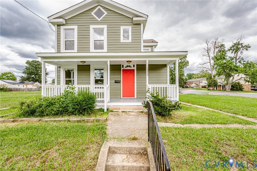 3903 Delmont Street, Henrico, VA 23222 Two-story residence featuring a covered front porch with white railings, a vibrant red entry door, and green siding
