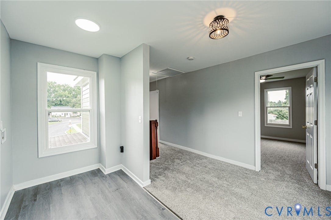 3903 Delmont Street, Henrico, VA 23222 Versatile interior space featuring light gray walls, white trim, and a mix of wood-finish flooring and gray carpeting
