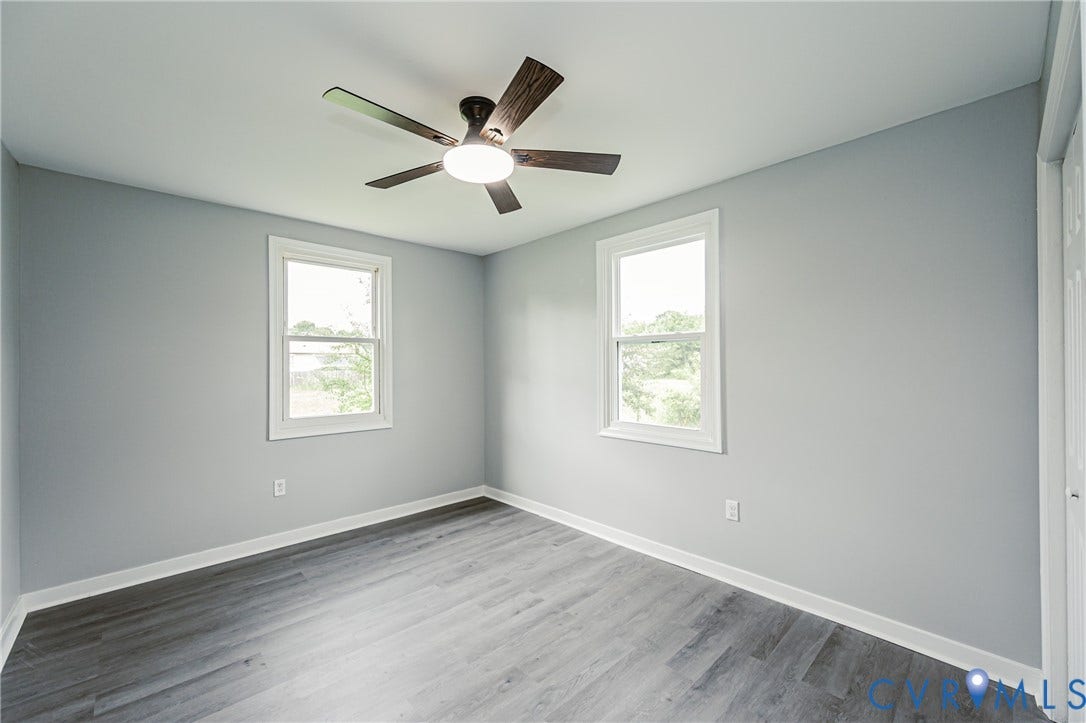 3903 Delmont Street, Henrico, VA 23222 Room featuring gray walls, wood-finish flooring, two white-framed windows, and a ceiling fan with integrated lighting