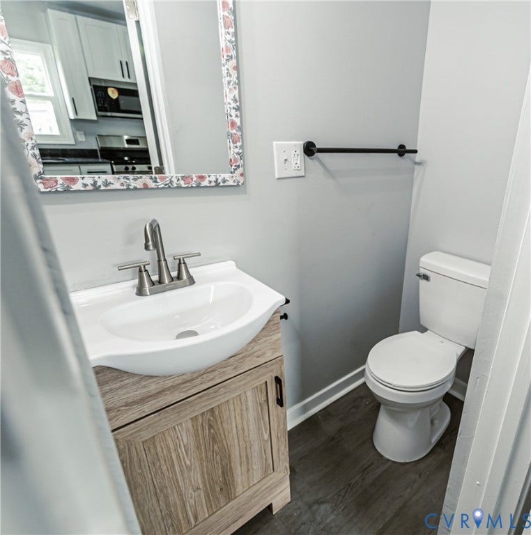 3903 Delmont Street, Henrico, VA 23222 Bathroom vanity with a white ceramic sink, brushed nickel faucet, and wood-finish cabinetry