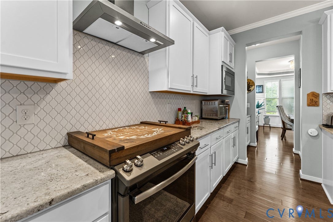 8800 Glen Royal Drive, Chesterfield, VA 23832 Kitchen featuring white cabinetry, light countertops, an arabesque tile backsplash, and stainless steel appliances