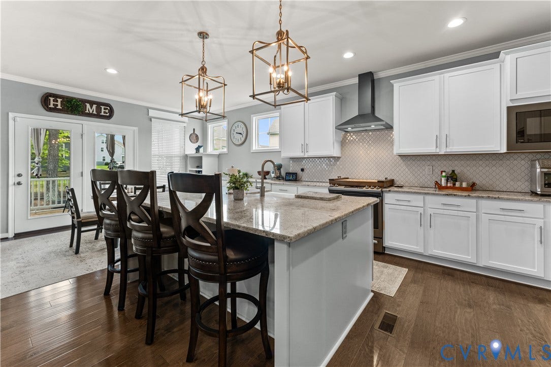 8800 Glen Royal Drive, Chesterfield, VA 23832 Kitchen featuring a large island with granite countertop, white cabinetry, integrated microwave, stainless steel range hood, and wood-finish flooring