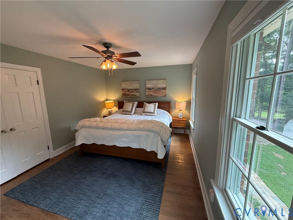 2312 Judes Ferry Road, Powhatan, VA 23139 Bright room featuring multiple windows with trim, a ceiling fan with integrated lighting, wood-finish flooring, and a paneled door