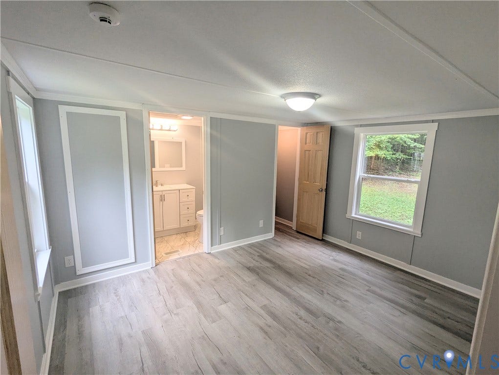 5959 Derwent Road, Powhatan, VA 23139 Spacious room featuring wood-finish flooring, light gray walls, white trim, and a ceiling light fixture