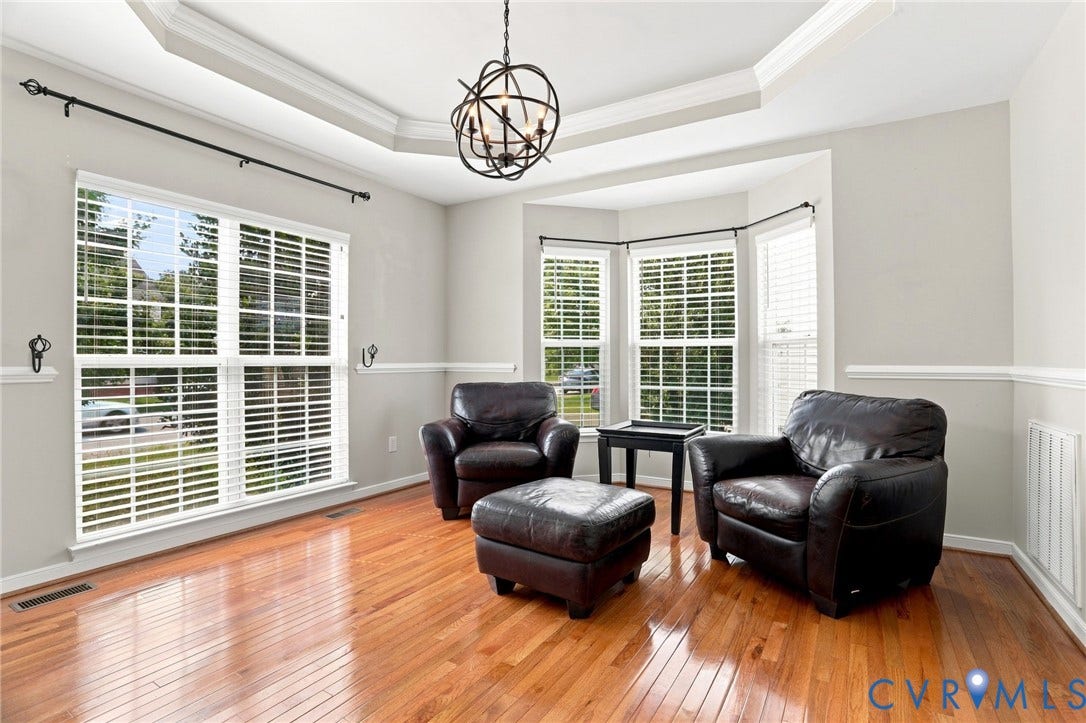 5713 Kings Grove Drive, Kings Grove, Chesterfield, VA 23832 Light-filled room featuring hardwood flooring, a tray ceiling with a spherical chandelier, and a bay window with white blinds