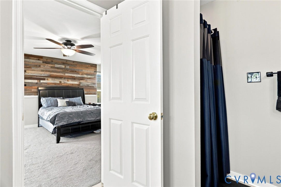 5713 Kings Grove Drive, Kings Grove, Chesterfield, VA 23832 Bedroom featuring an accent wall with wood-finish paneling, a ceiling fan with integrated lighting, and light-colored carpeting