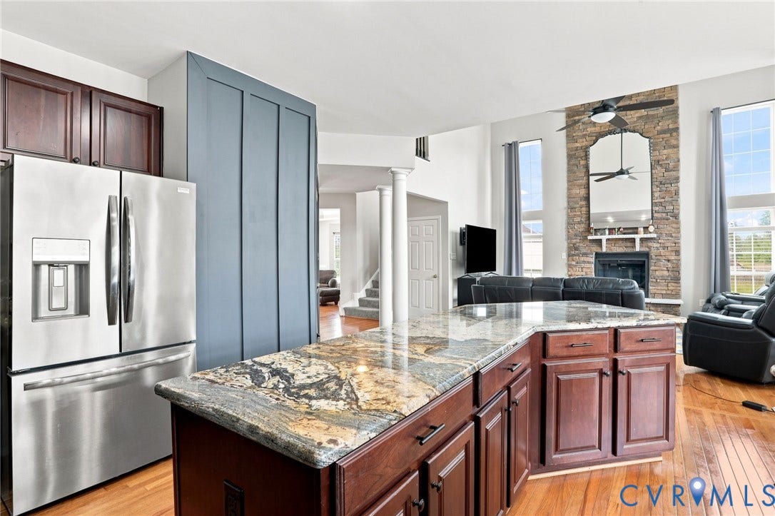 5713 Kings Grove Drive, Kings Grove, Chesterfield, VA 23832 Kitchen island featuring a patterned stone countertop and dark wood-finish cabinetry