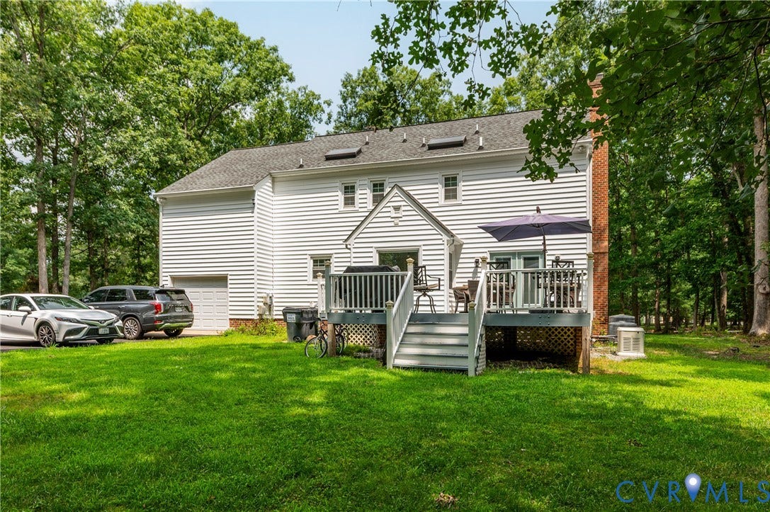11611 Riverpark Way, Chesterfield, VA 23838 Rear exterior showcasing a spacious wood deck with steps to the yard, white siding, and a single-car garage