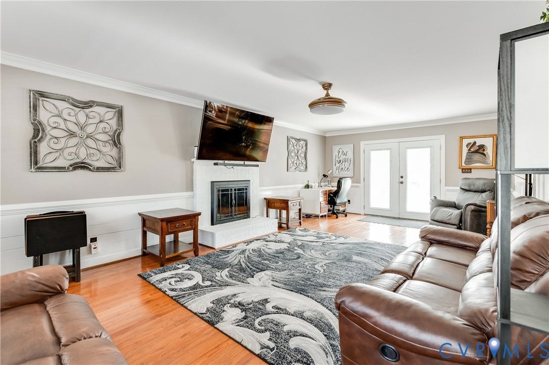 11611 Riverpark Way, Chesterfield, VA 23838 Living area featuring wood-finish flooring, a white brick fireplace, and crown molding