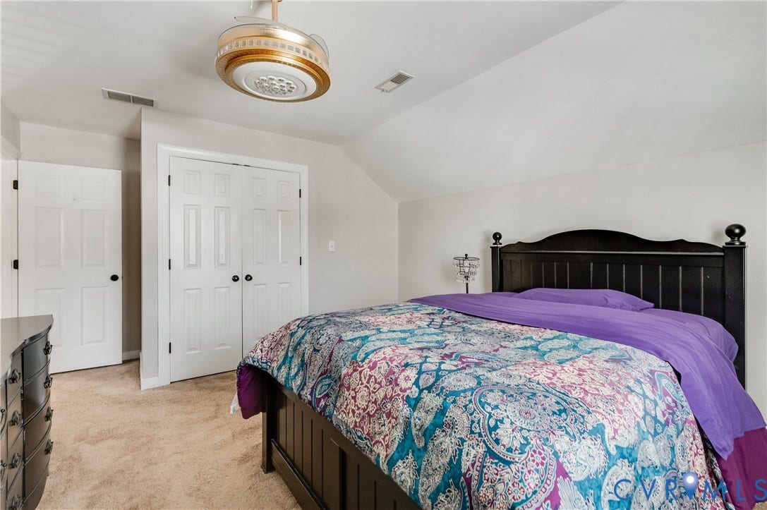 11611 Riverpark Way, Chesterfield, VA 23838 Carpeted room featuring a ceiling fan with integrated lighting, two white panel doors, and neutral wall paint