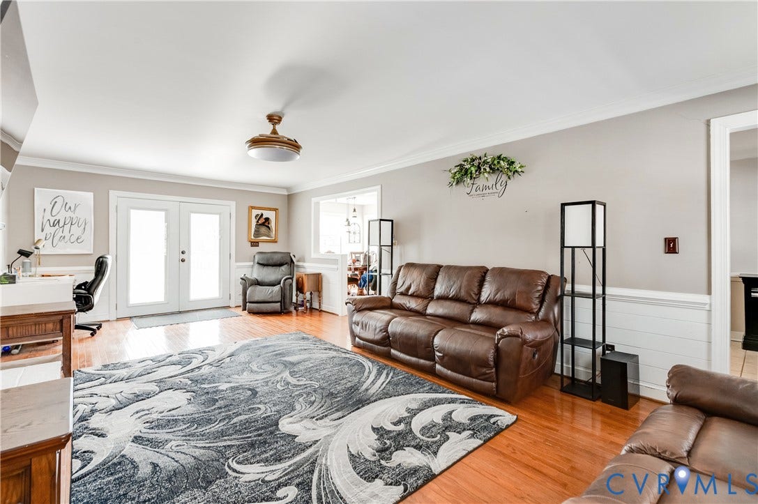 11611 Riverpark Way, Chesterfield, VA 23838 Spacious living area featuring wood-finish flooring, white shiplap wainscoting, and crown molding