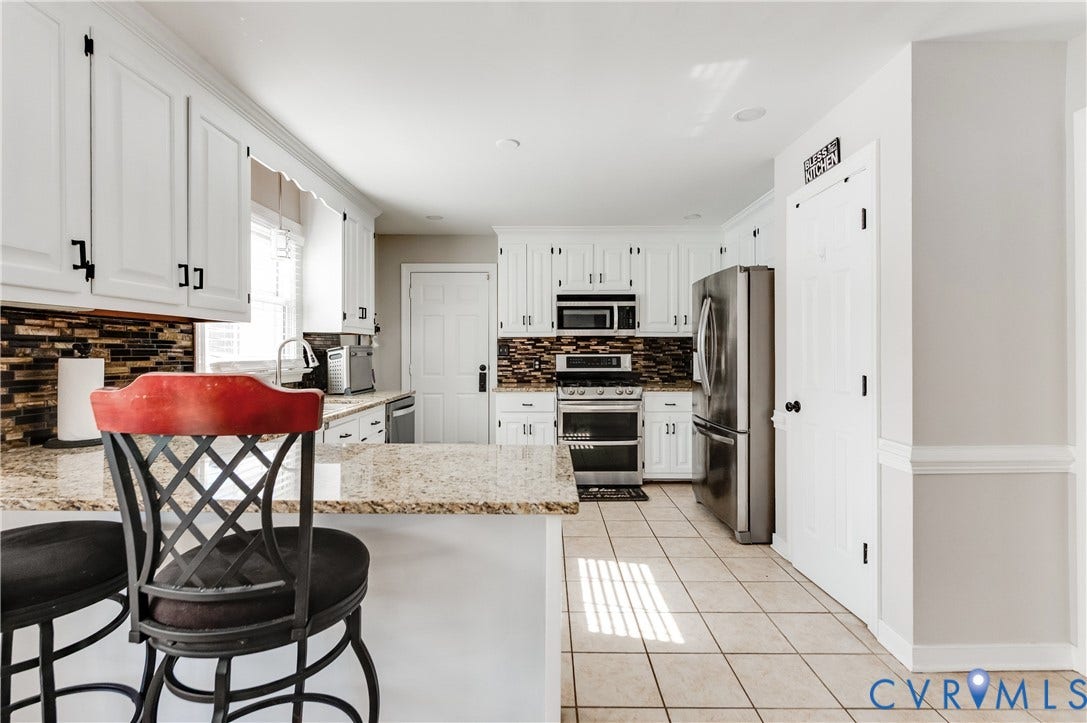 11611 Riverpark Way, Chesterfield, VA 23838 Kitchen featuring white cabinetry, granite countertops, tile backsplash, stainless steel appliances, and ceramic tile flooring