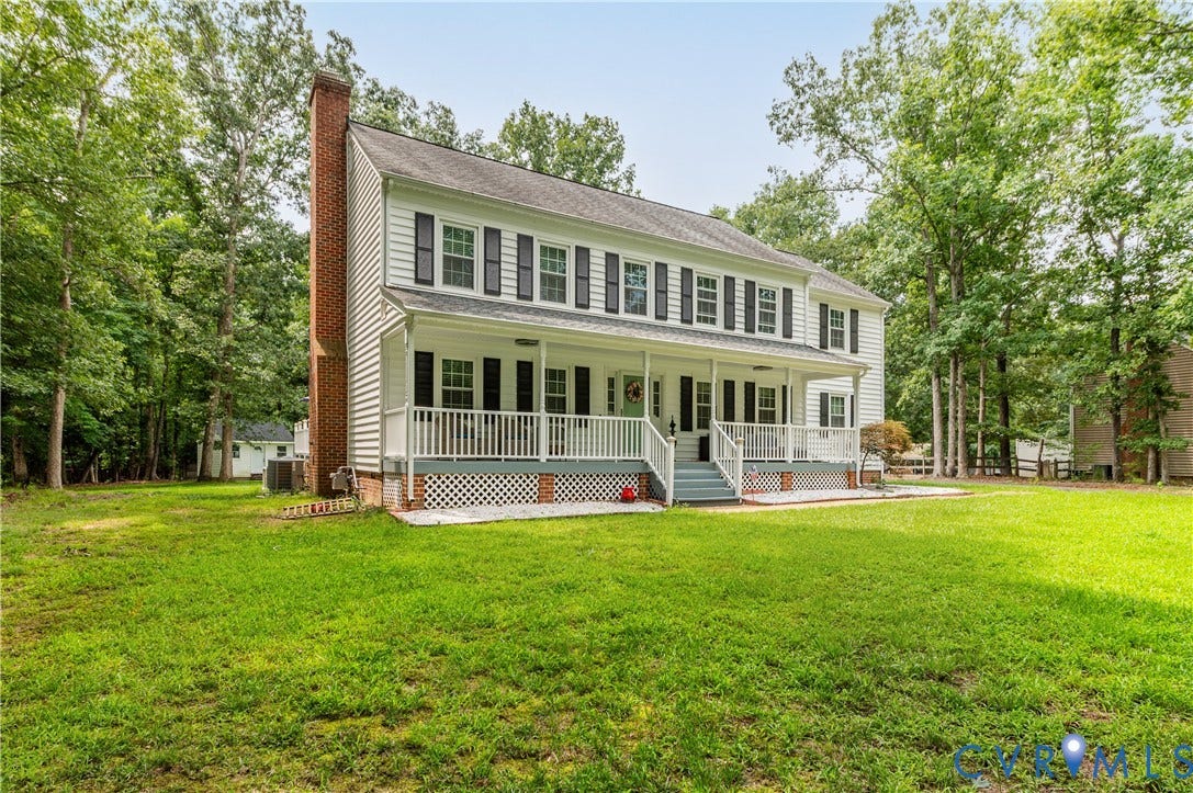 11611 Riverpark Way, Chesterfield, VA 23838 Two-story Colonial-style residence featuring white siding, a covered front porch with white railings, and a prominent brick chimney