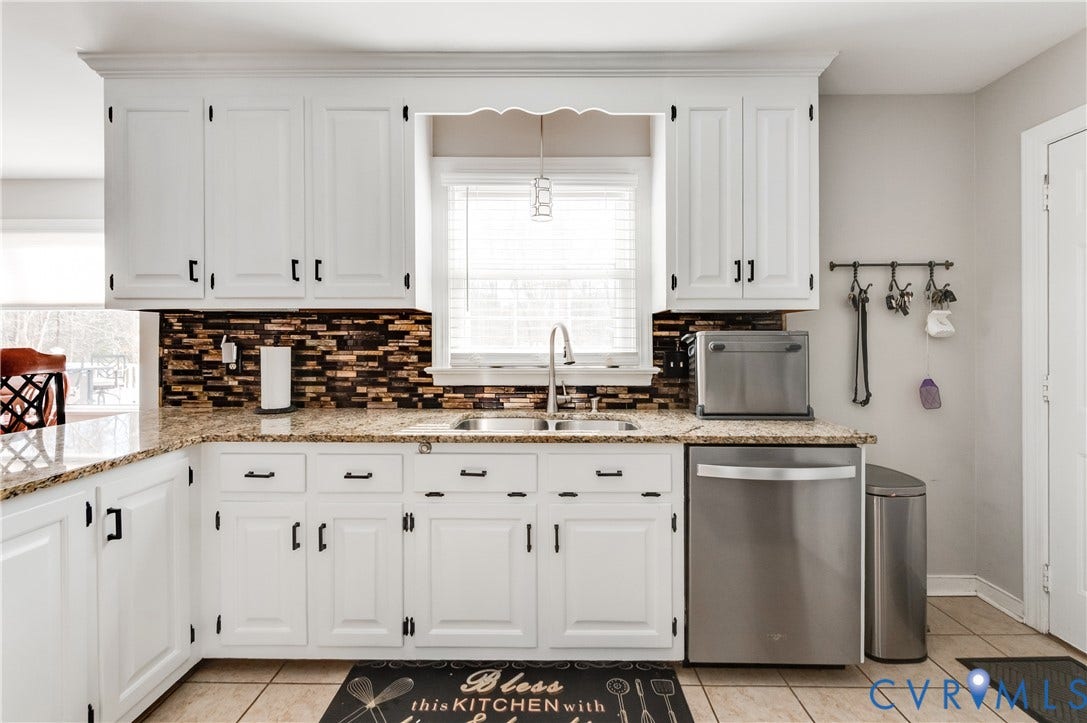 11611 Riverpark Way, Chesterfield, VA 23838 Kitchen featuring white cabinetry with dark hardware, a brown mosaic tile backsplash, and light-toned countertop