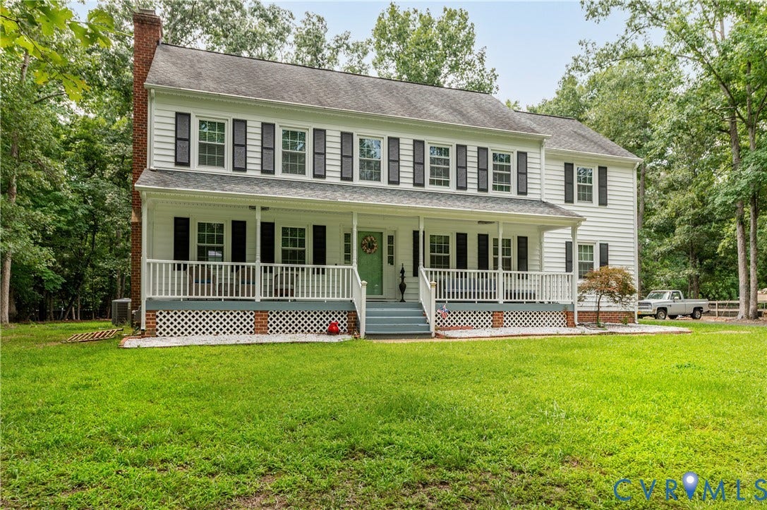 11611 Riverpark Way, Chesterfield, VA 23838 Two-story white siding residence featuring a full-width covered porch with white railing, black louvered shutters, and a prominent brick chimney