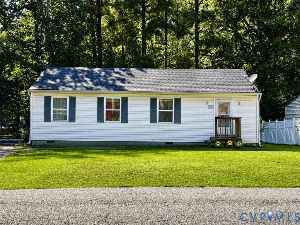 White siding exterior with a dark shingle roof, featuring dark shutters on multiple windows and a wooden front porch