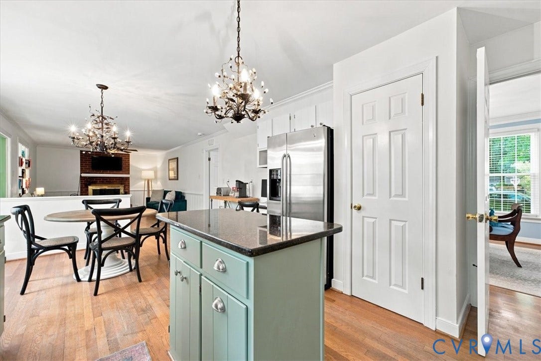 10204 Steuben Drive, Henrico, VA 23060 Kitchen area featuring a central island with a dark countertop and light green cabinetry, stainless steel refrigerator, and hardwood-finish flooring