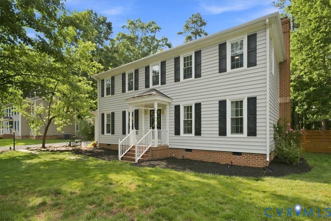10204 Steuben Drive, Henrico, VA 23060 Traditional two-story residence featuring light gray siding, black shutters, white window trim, and a brick foundation