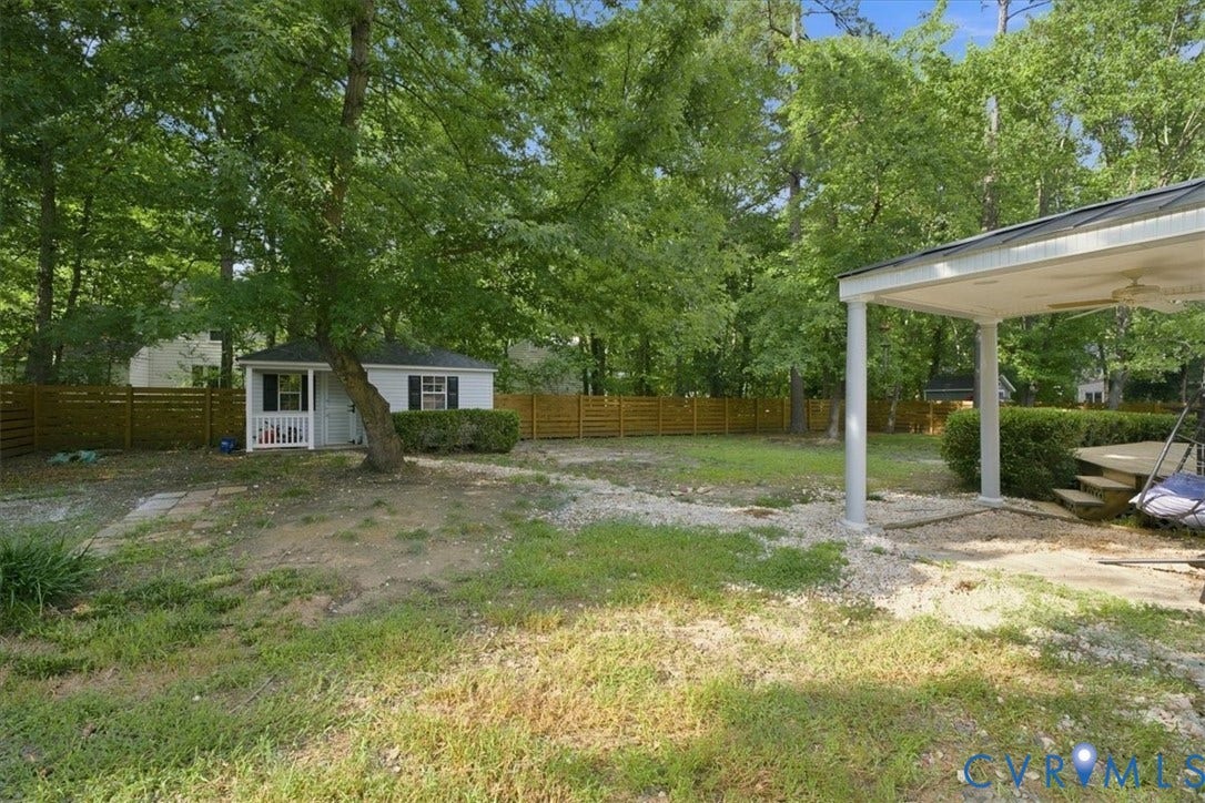 10204 Steuben Drive, Henrico, VA 23060 Spacious backyard featuring a white storage shed with a porch, a covered patio area, and a horizontal wood fence