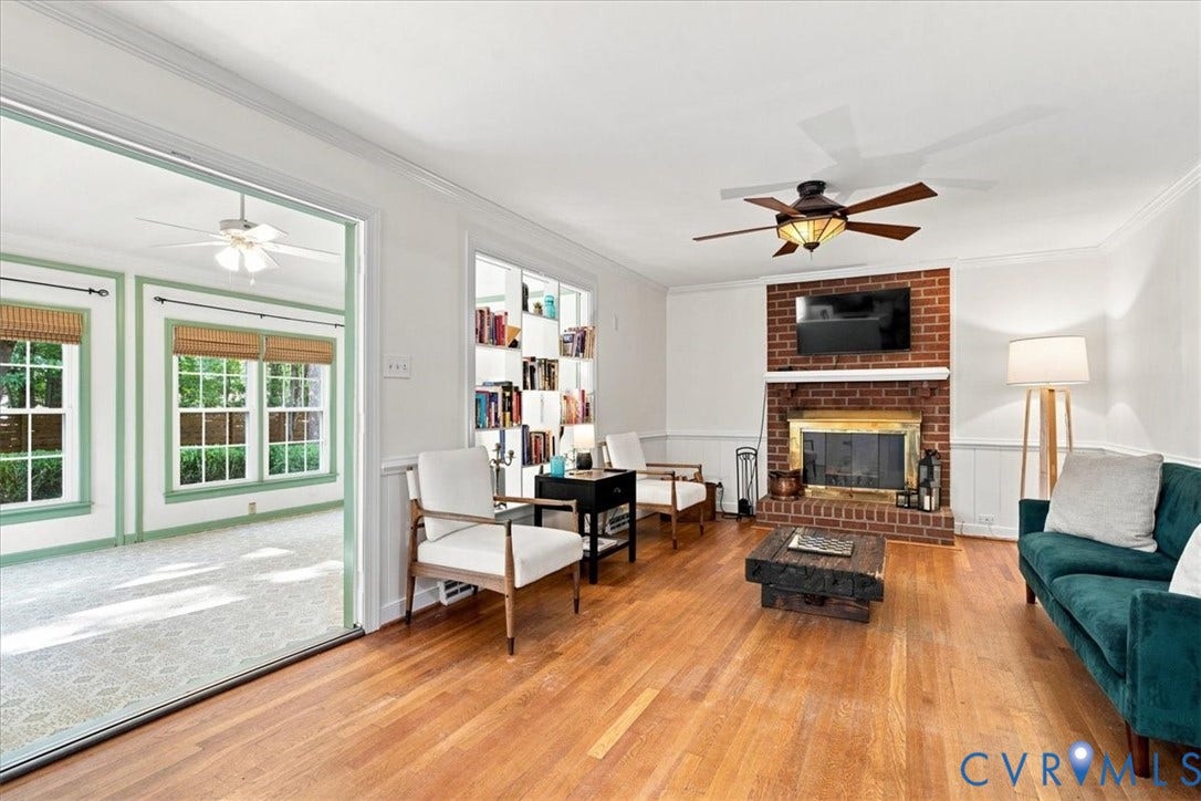 10204 Steuben Drive, Henrico, VA 23060 Hardwood flooring in the main living space with a brick fireplace, brass firebox, and a ceiling fan
