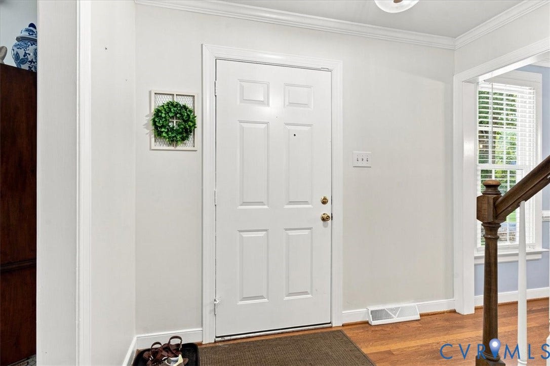 10204 Steuben Drive, Henrico, VA 23060 Entryway featuring a paneled white door with brass hardware, crown molding, and wood-finish flooring