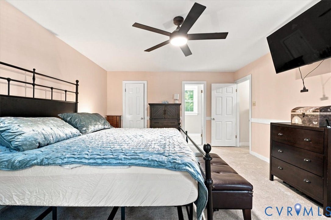 10204 Steuben Drive, Henrico, VA 23060 Carpeted bedroom featuring a ceiling fan with integrated lighting, multiple paneled doors, and wainscoting