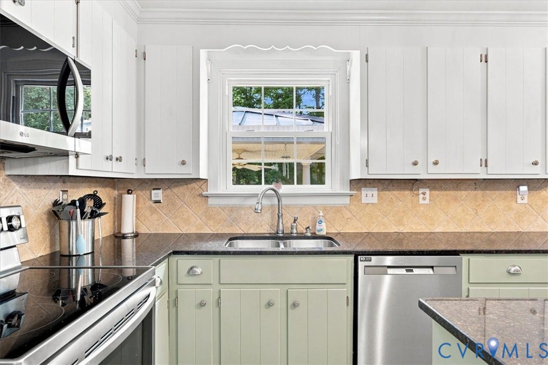 10204 Steuben Drive, Henrico, VA 23060 Kitchen featuring white upper cabinetry, sage green lower cabinetry, a stainless steel sink with a gooseneck faucet, black countertops, and a diagonally set tile backsplash