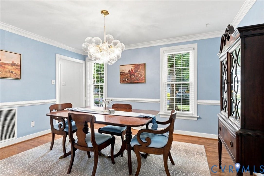 10204 Steuben Drive, Henrico, VA 23060 Dining area featuring a contemporary bubble chandelier, two large windows, white crown molding, chair rail molding, and wood-finish flooring