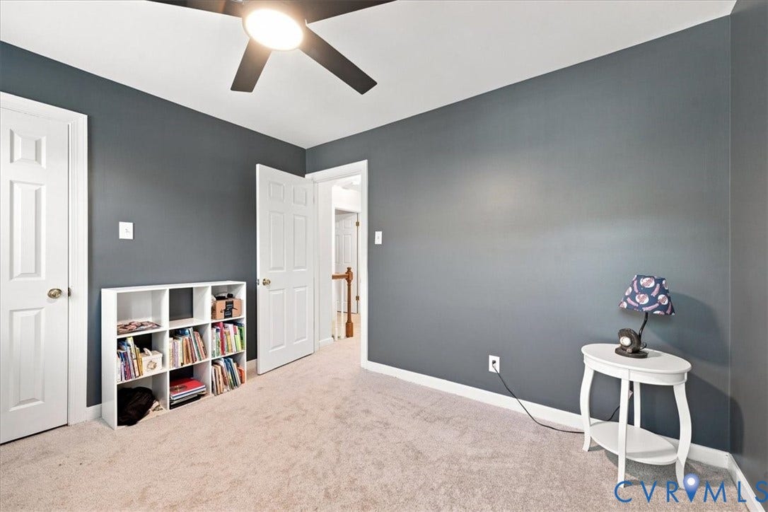 10204 Steuben Drive, Henrico, VA 23060 Carpeted interior room featuring a ceiling fan with integrated lighting, two white panel doors, and contrasting dark gray and white wall finishes