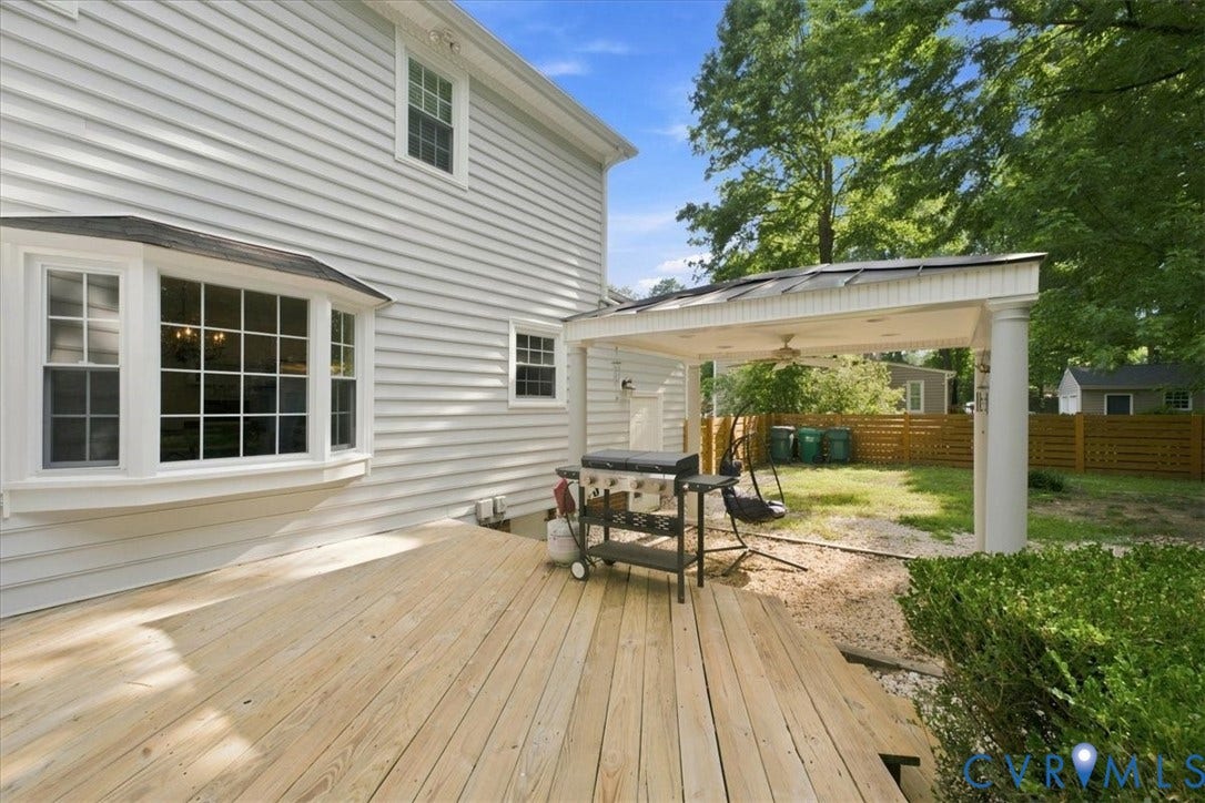 10204 Steuben Drive, Henrico, VA 23060 Expansive wood deck with a covered patio featuring a columned support and a ceiling fan
