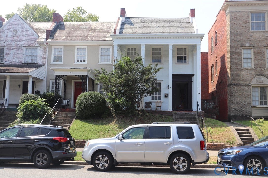 1119 W Grace Street, The Fan District, Richmond, VA 23220 Two-story white residence with prominent front columns, a dark entry door, and dark window trim