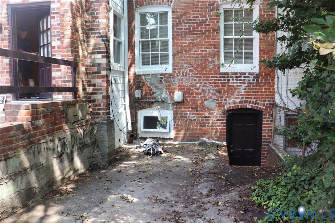1119 W Grace Street, The Fan District, Richmond, VA 23220 Brick exterior featuring multiple windows and a black paneled door with an arched brick surround