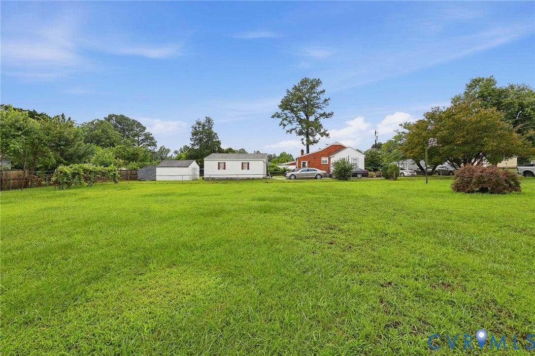 5002 Glendale Avenue, Dinwiddie, VA 23803 Expansive green space featuring a large grassy area, a detached storage shed, and a privacy fence