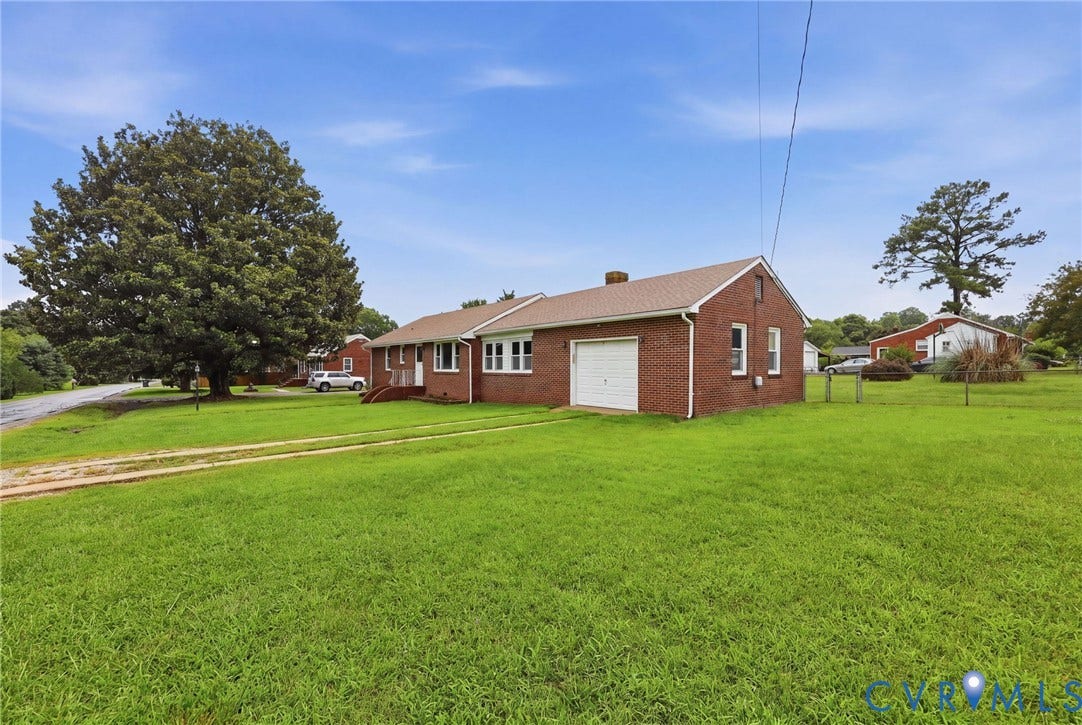5002 Glendale Avenue, Dinwiddie, VA 23803 Brick ranch home situated on expansive manicured grounds featuring mature shade trees, a detached garage with overhead door, and ample green lawn space